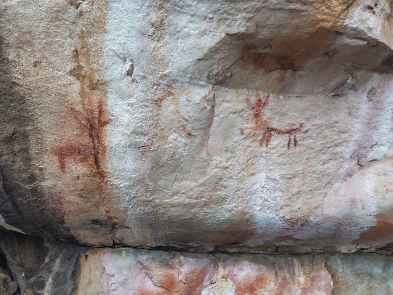 Pinturas rupestres discretas em um paredão de pedra